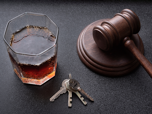 gavel, set of car keys, and a glass of alcohol